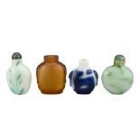 FOUR CHINESE SNUFF BOTTLES. Comprising an amber-coloured glass bottle with two mask and ring