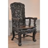 A CHINESE HARDWOOD ARMCHAIR, 19TH CENTURY. Heavily carved throughout with carved and pierced back