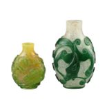 TWO CHINESE GLASS SNUFF BOTTLES. To include a green-overlay glass bottle with chilong. Together with