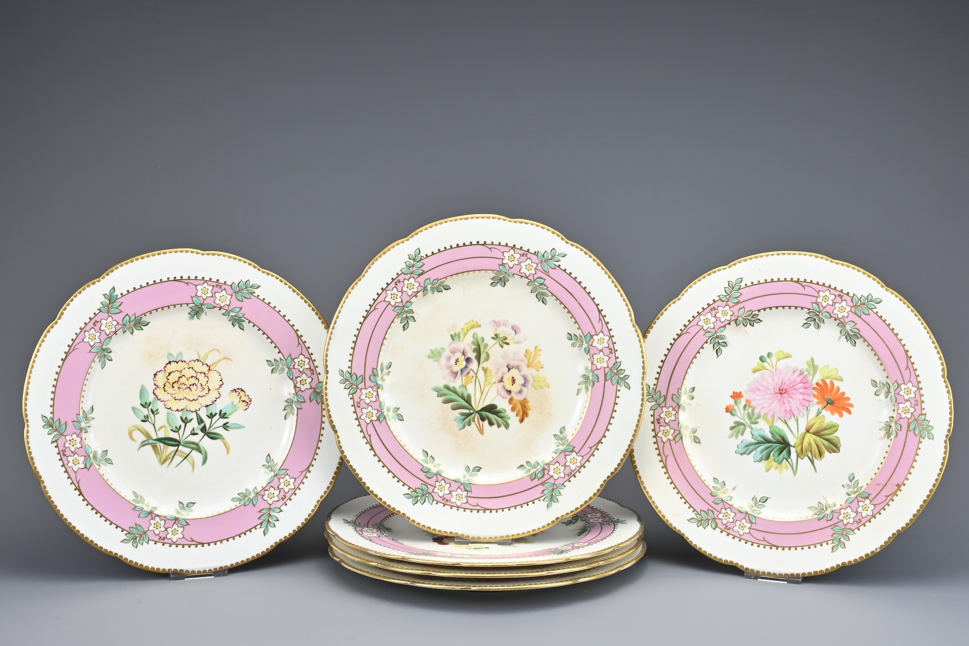 SET OF SIX VICTORIAN PORCELAIN DESSERT PLATES with a floral and gilt border surrounding central