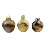 THREE CHINESE SNUFF BOTTLES. Comprising two agate bottles with green stone stoppers, one with
