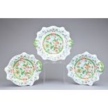 THREE STONE CHINA DISHES, with green ground and gilt details, one with two handles, diameter