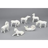 A GROUP OF SEVEN VINTAGE WHITE GLAZED PORCELAIN HORSES. In various poses. 8-9cm length. (7)