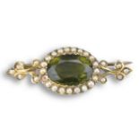 AN ANTIQUE PERIDOT AND SEAD PEARL PIN BROOCH. Faceted cabochon surrounded by seed pearls mounted