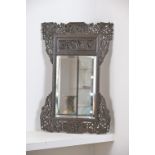 A CHINESE HEAVILY CARVED WOOD FRAMED MIRROR, EARLY 20TH CENTURY. The elaborate frame pierced and