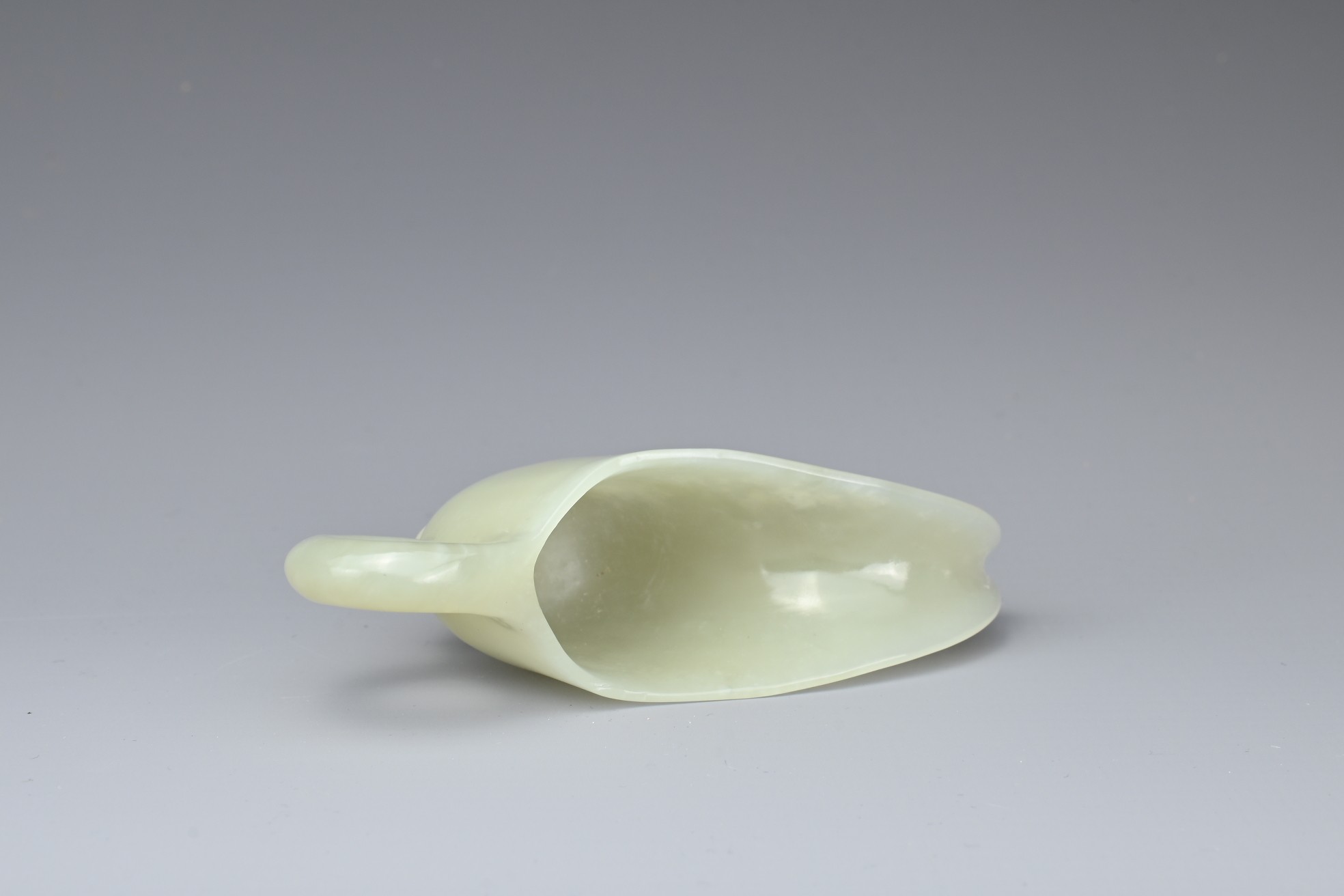 A CHINESE PALE CELADON JADE CUP. Of slender form with a looped handle and curved spout. 10.5cm - Image 7 of 7