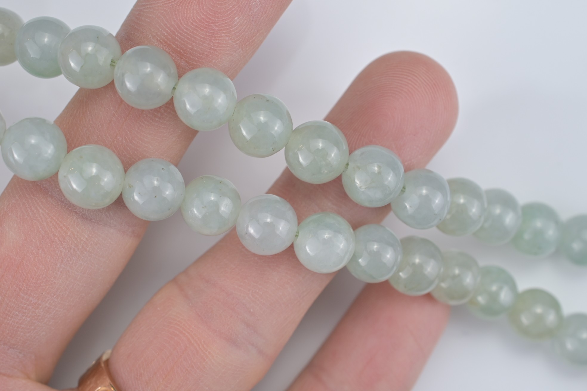A PALE GREEN JADEITE SINGLE STRAND BEADED NECKLACE WITH 18KT YELLOW GOLD CLASP. The marquise- - Image 6 of 7