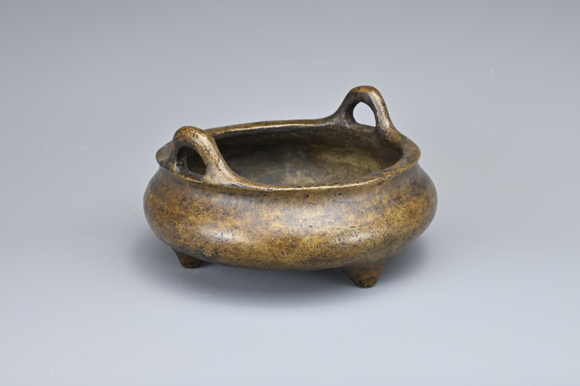 A CHINESE BRONZE TRIPOD CENSER. Of squat circular form with two looped handles on three conical - Image 3 of 9