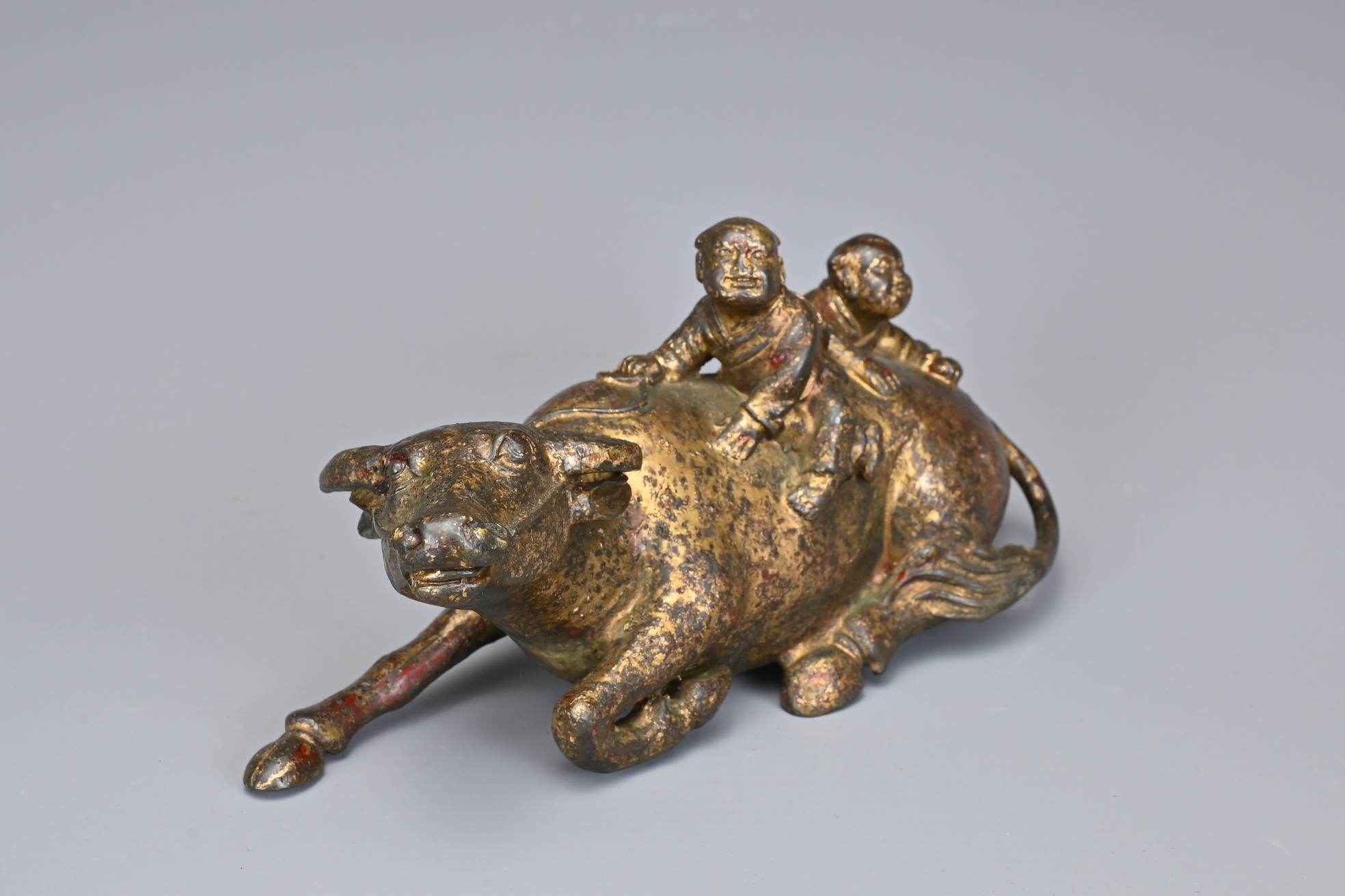 A CHINESE GILT BRONZE MODEL OF A BUFFALO AND BOYS. The recumbent buffalo wearing a rein with on - Image 2 of 7