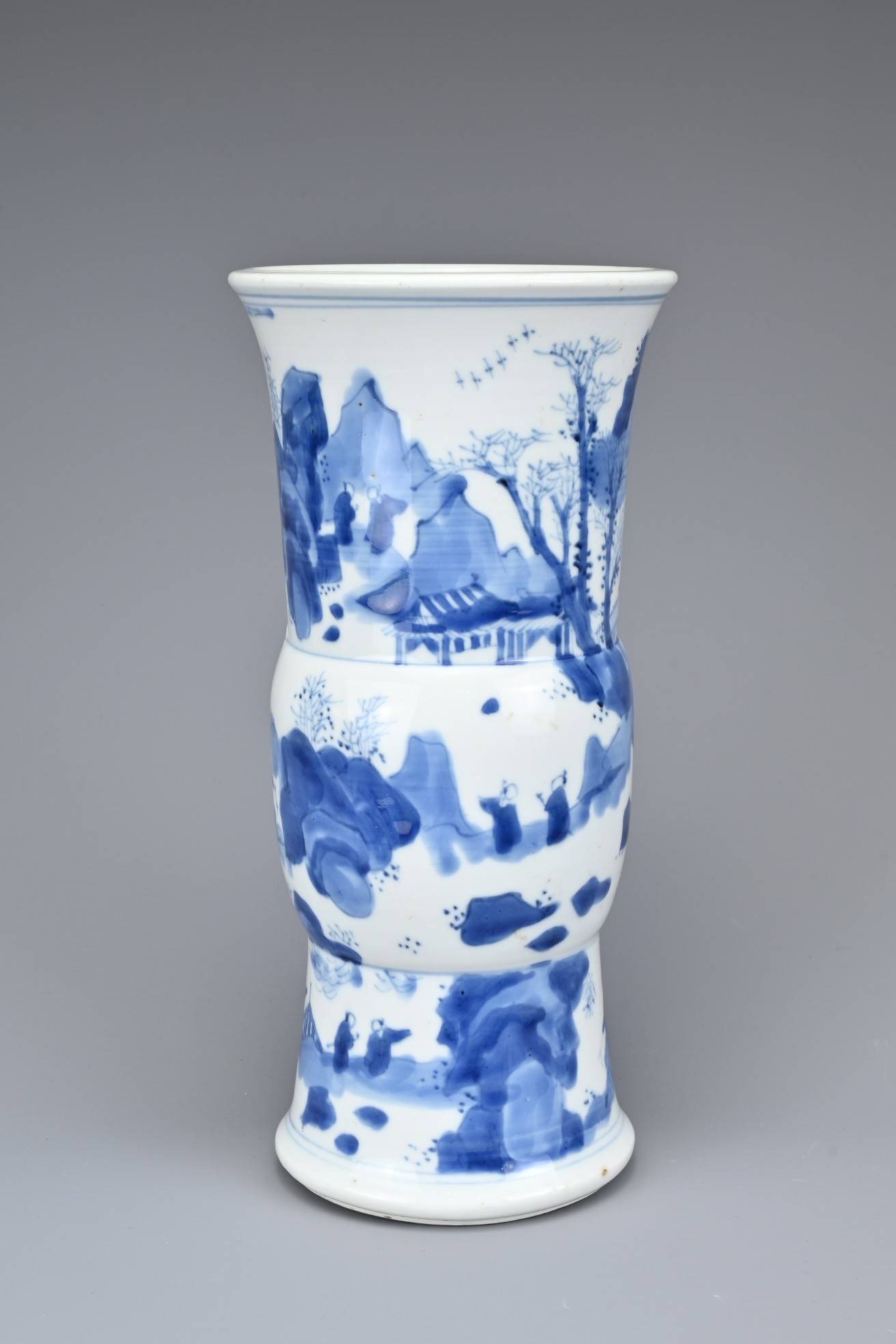 A CHINESE BLUE AND WHITE PORCELAIN GU SHAPED VASE. Fairly thickly potted, decorated with figures and