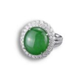 AN 18KT WHITE GOLD, DIAMOND AND JADEITE DRESS RING. An oval shaped cabochon mounted in white gold