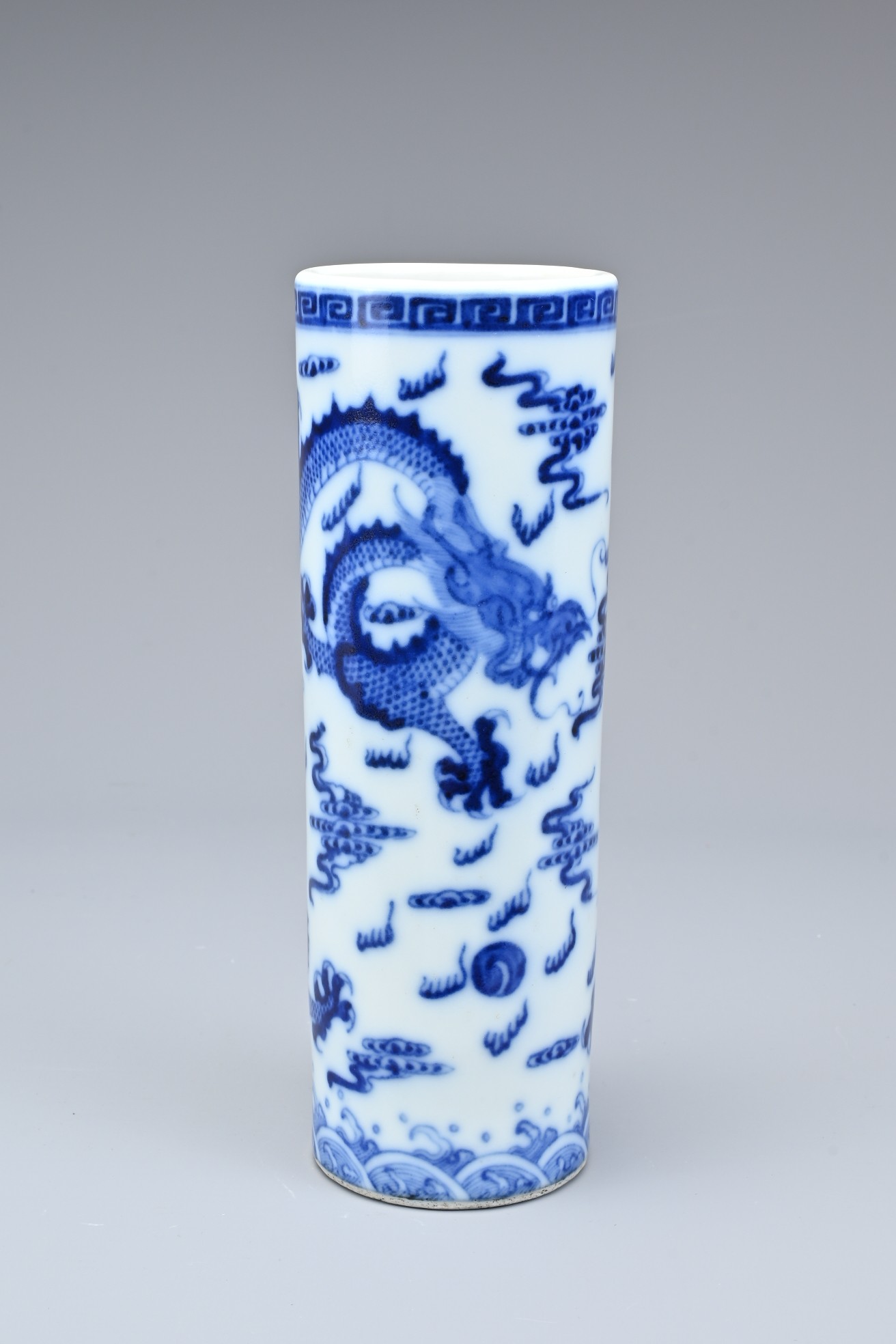 A CHINESE BLUE AND WHITE PORCELAIN BRUSH POT, 20TH CENTURY. Of cylindrical form with continuous