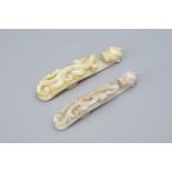 TWO CHINESE GREY AND PALE CELADON JADE BELT BUCKLES. Each pierced and carved with dragon head