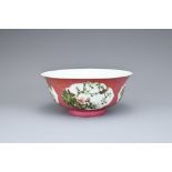 A CHINESE RUBY GROUND FAMILLE ROSE SGRAFFITO PORCELAIN BOWL, 20TH CENTURY. Rounded sides leading