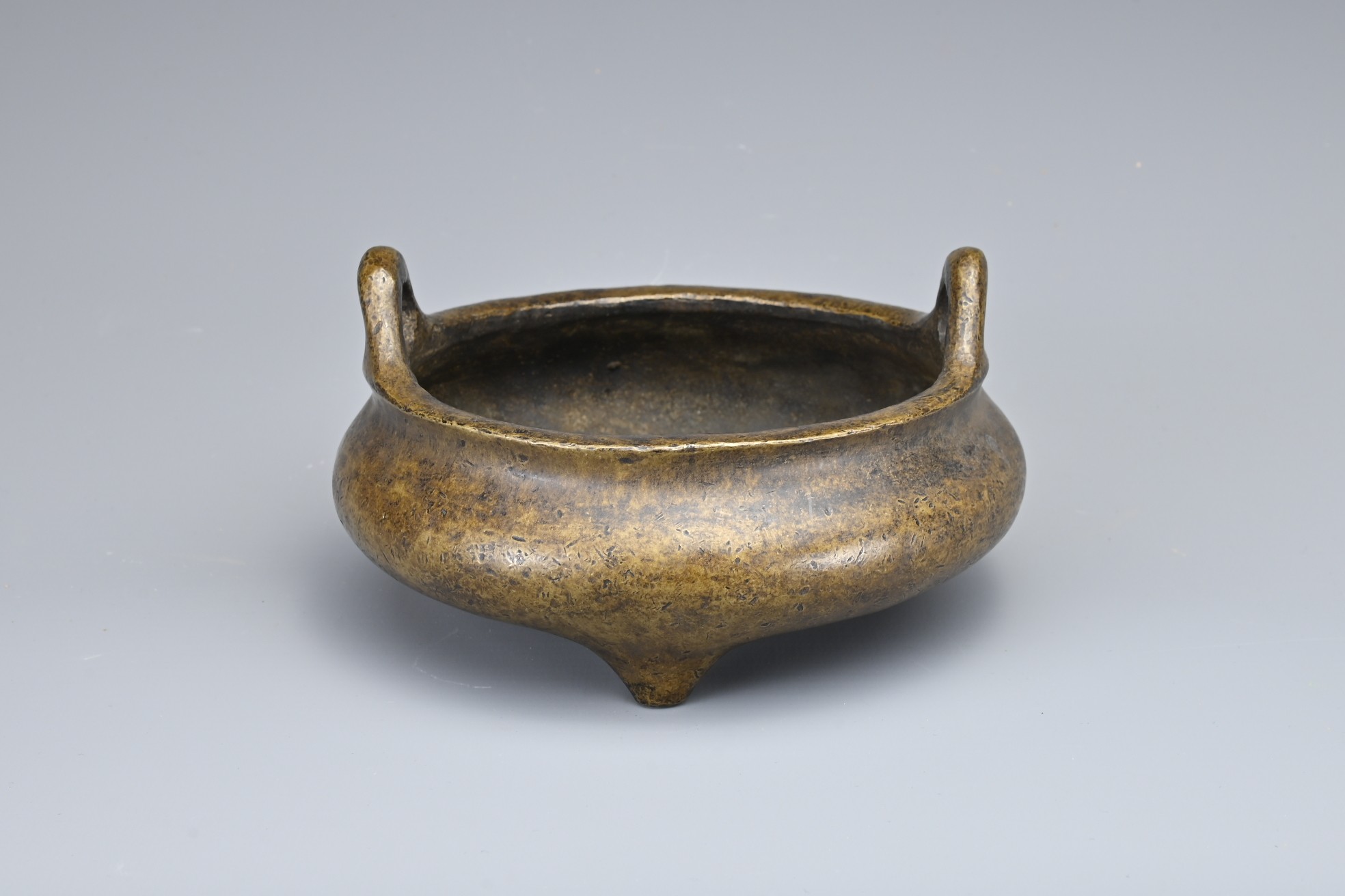 A CHINESE BRONZE TRIPOD CENSER. Of squat circular form with two looped handles on three conical - Image 2 of 9