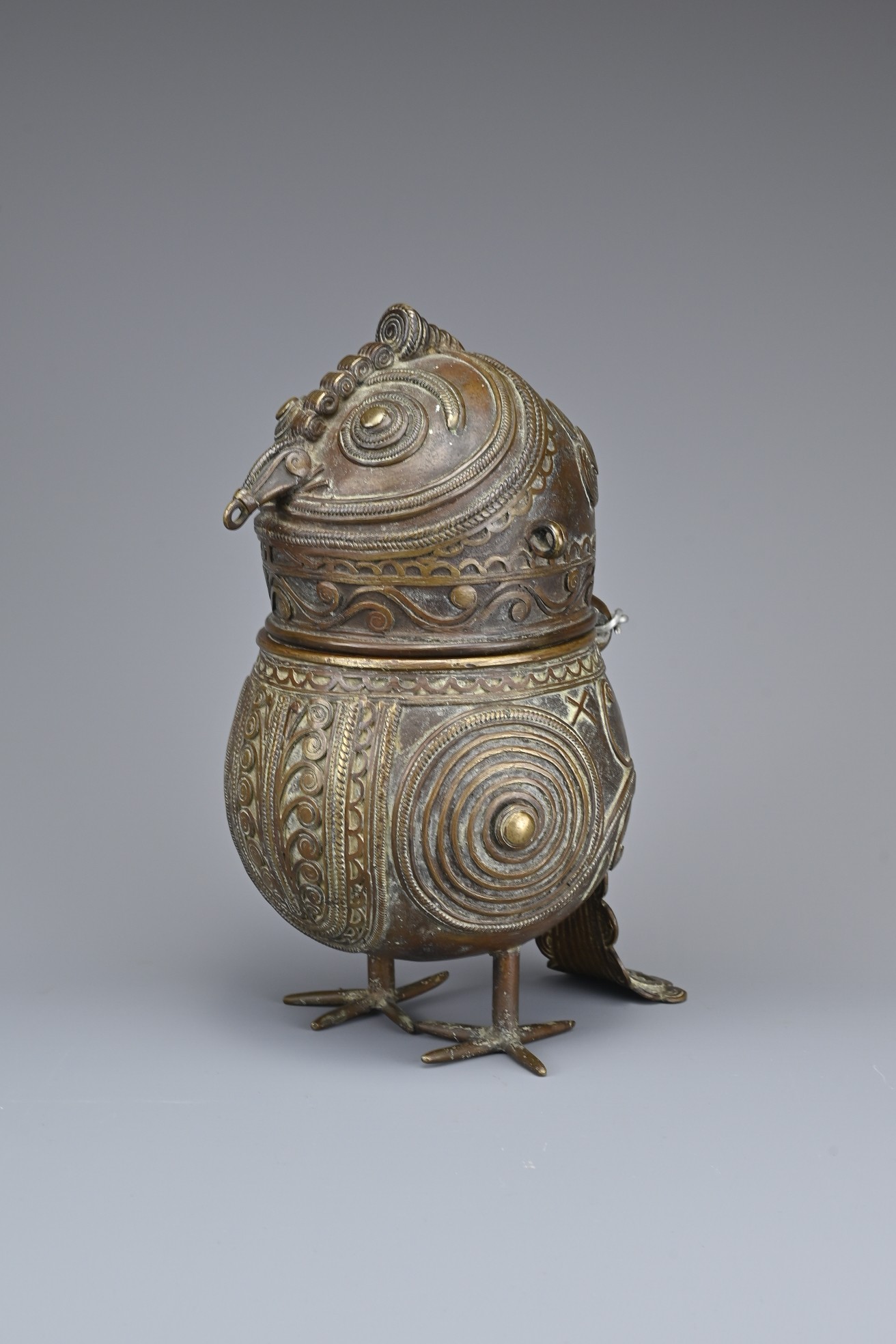AN INDIAN BRONZE DHOKRA TYPE 'OWL' CONTAINER. Hinged at the back of the next standing on two feet