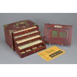 A CHINESE MAHJONG SET, EARLY 20TH CENTURY. Wooden carrying box with brass mounts and handle,
