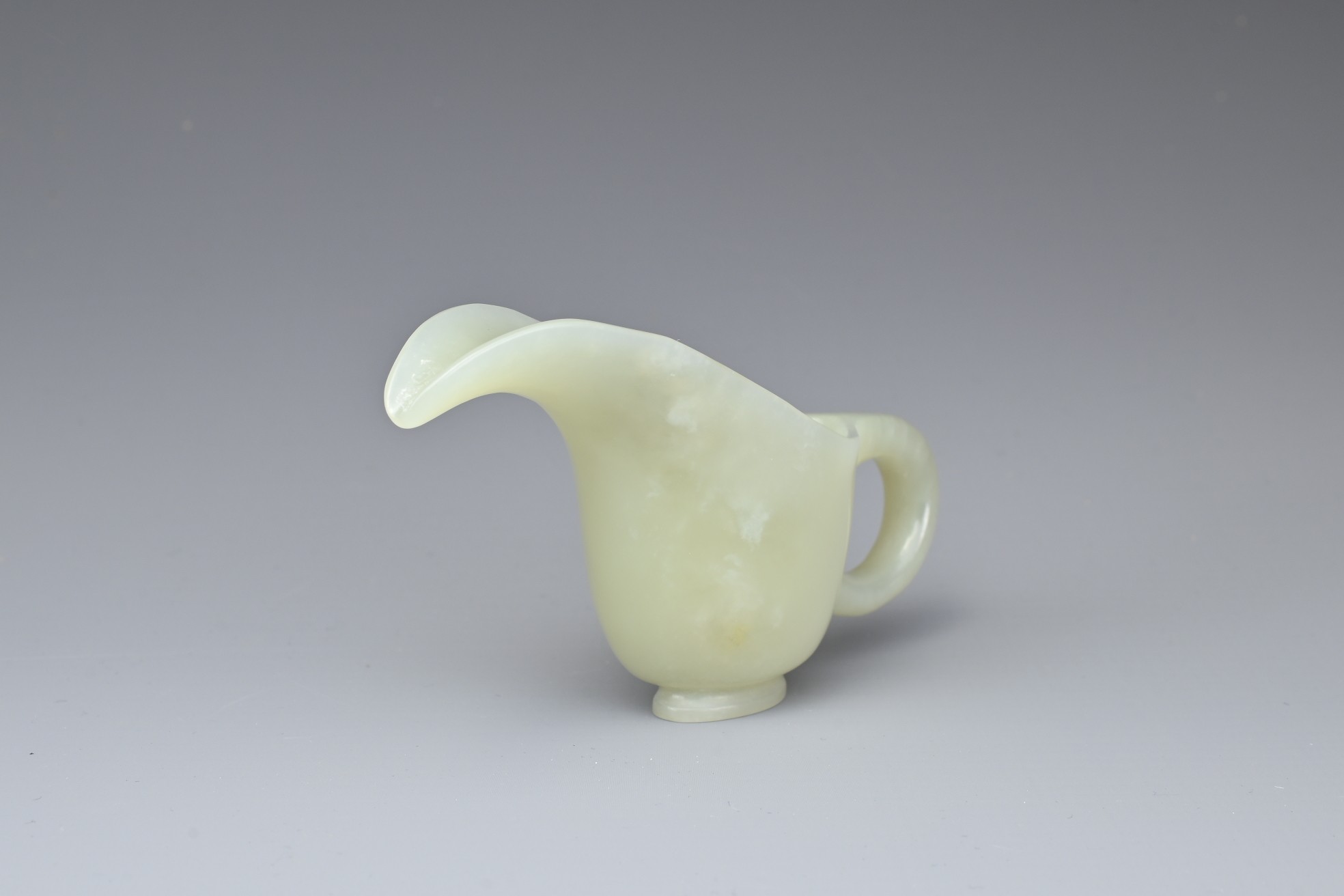 A CHINESE PALE CELADON JADE CUP. Of slender form with a looped handle and curved spout. 10.5cm - Image 2 of 7