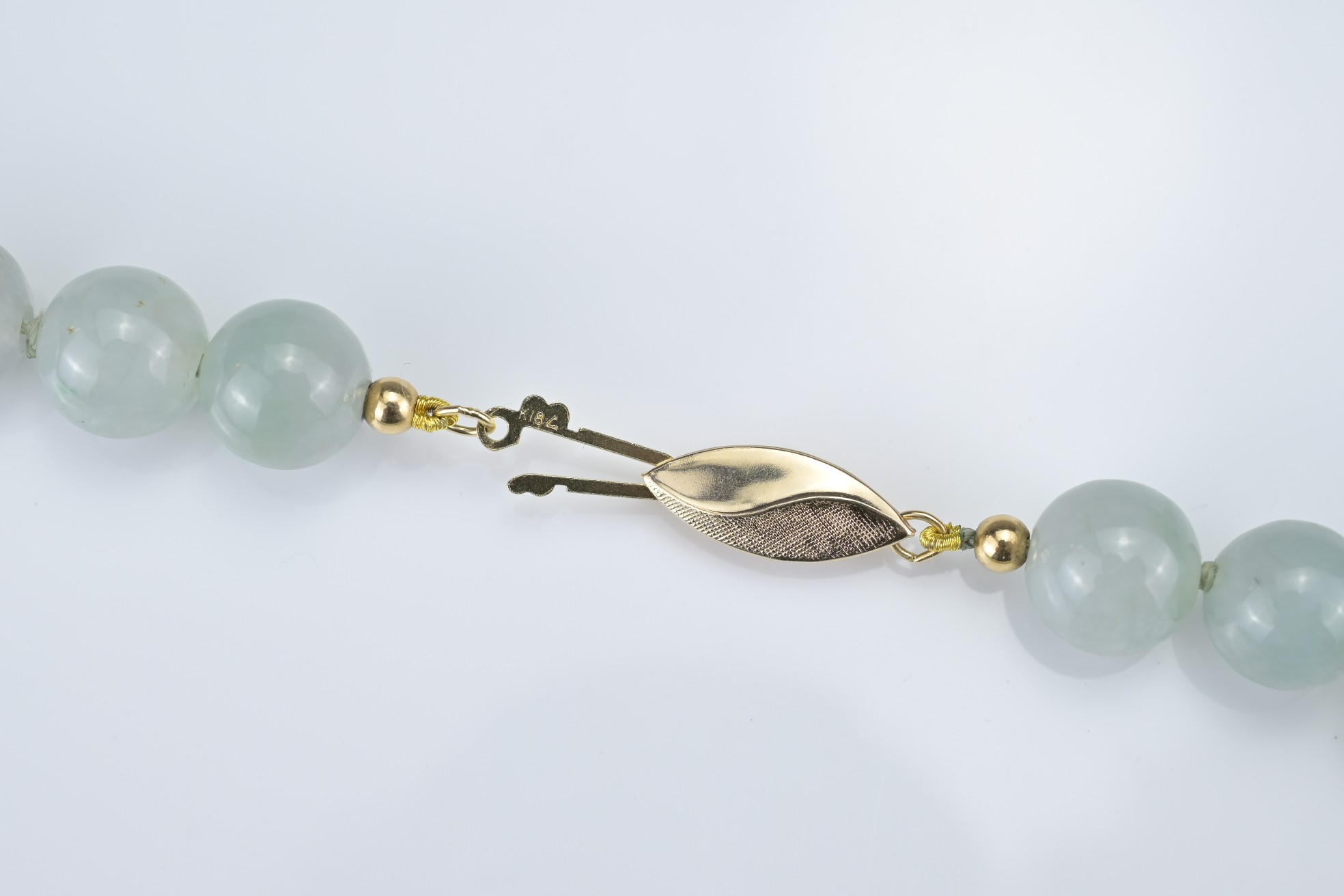 A PALE GREEN JADEITE SINGLE STRAND BEADED NECKLACE WITH 18KT YELLOW GOLD CLASP. The marquise- - Image 4 of 7