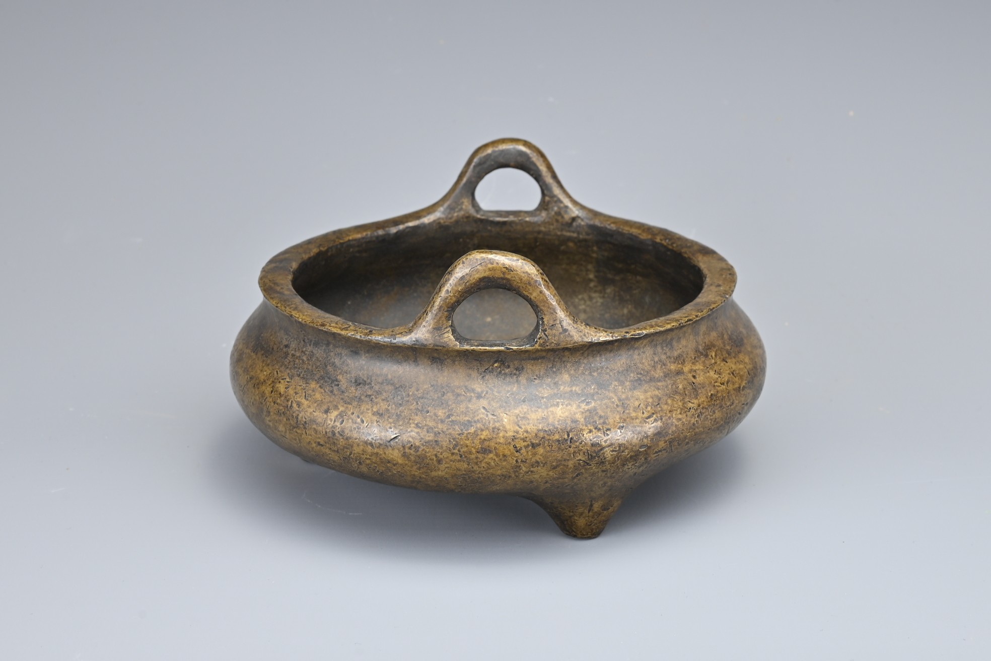 A CHINESE BRONZE TRIPOD CENSER. Of squat circular form with two looped handles on three conical - Image 6 of 9