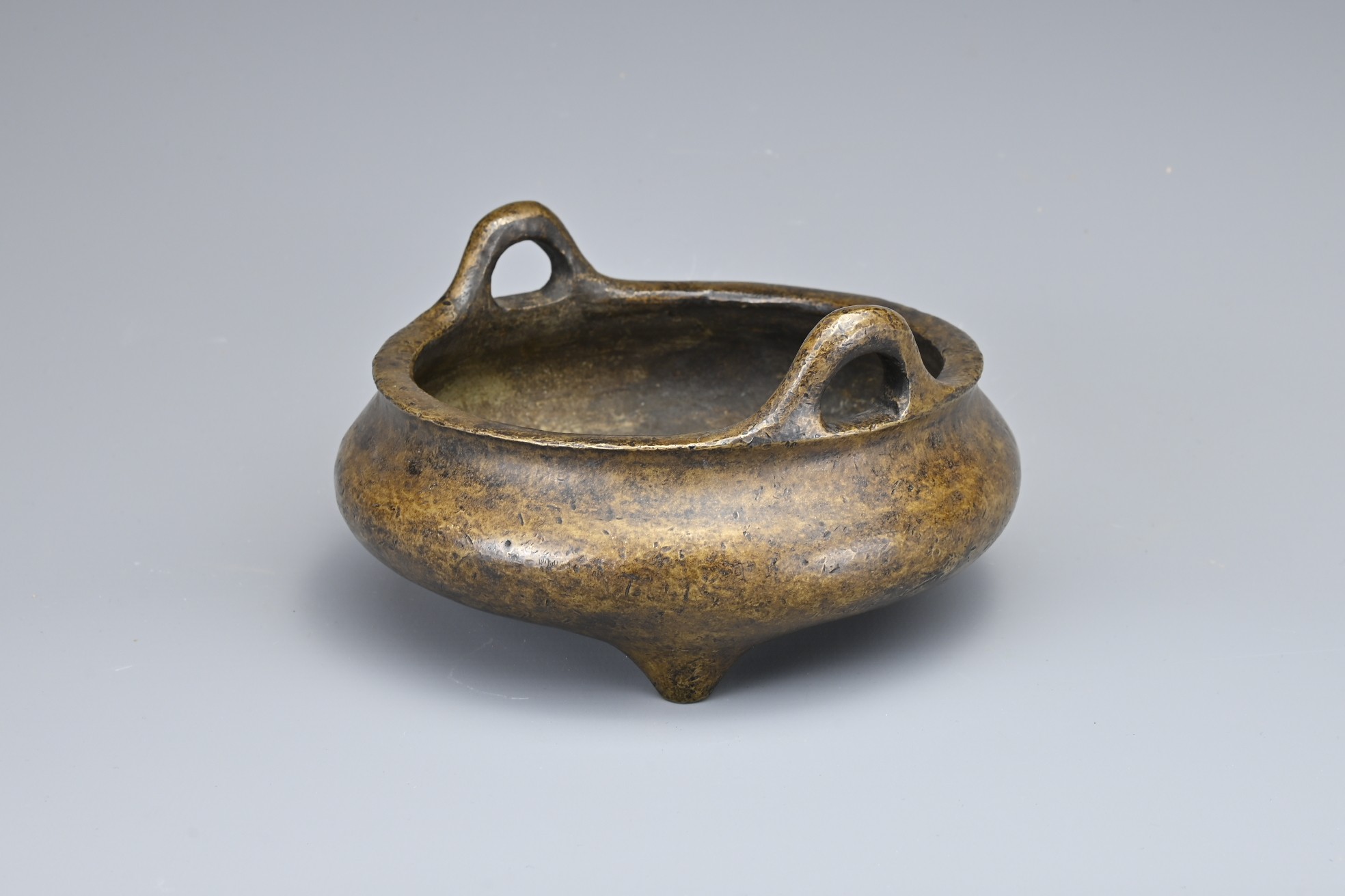A CHINESE BRONZE TRIPOD CENSER. Of squat circular form with two looped handles on three conical - Image 4 of 9