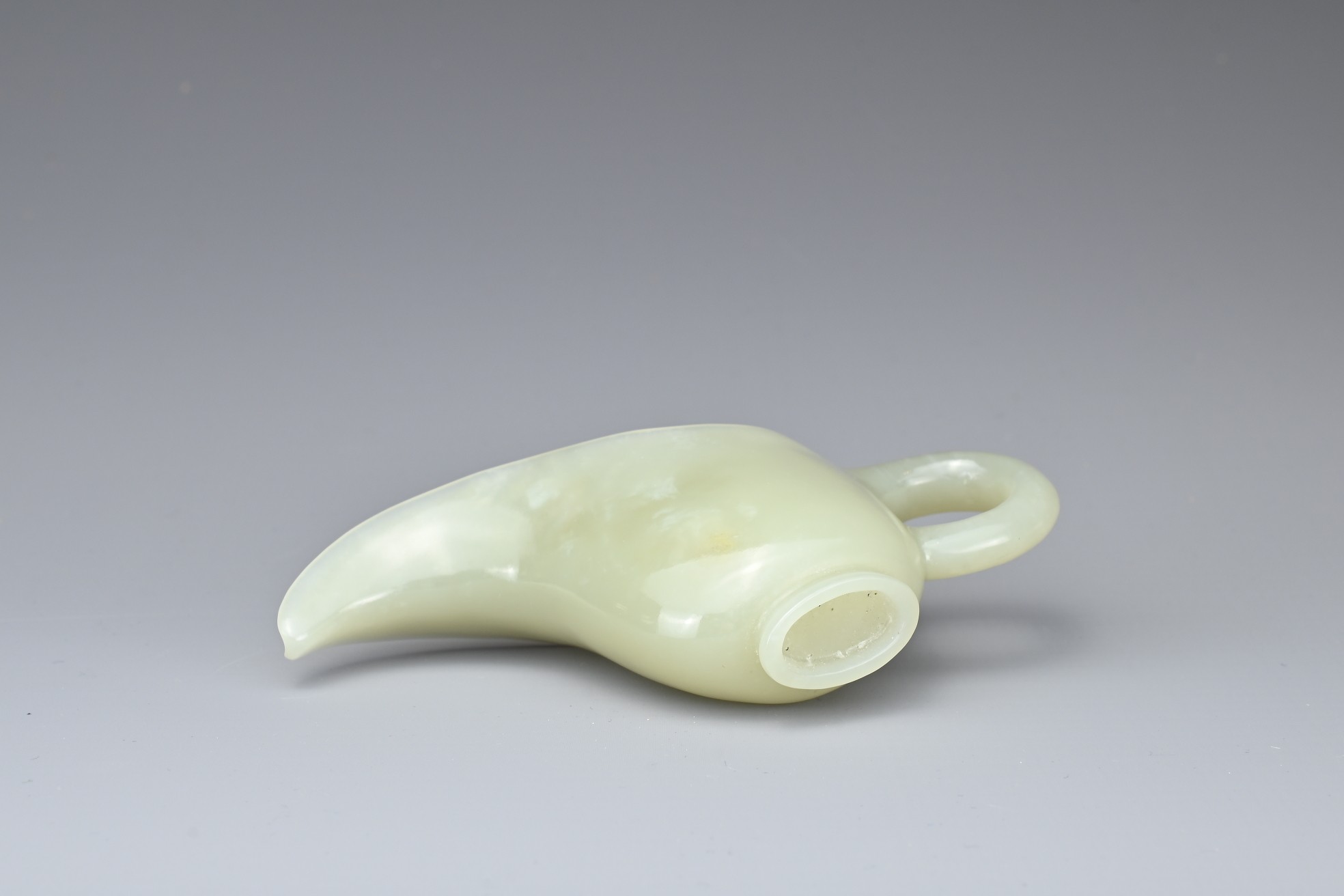 A CHINESE PALE CELADON JADE CUP. Of slender form with a looped handle and curved spout. 10.5cm - Image 6 of 7