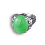 AN 18KT WHITE GOLD, DIAMOND AND JADEITE DRESS RING. With oval shaped cabochon, in pierced white gold