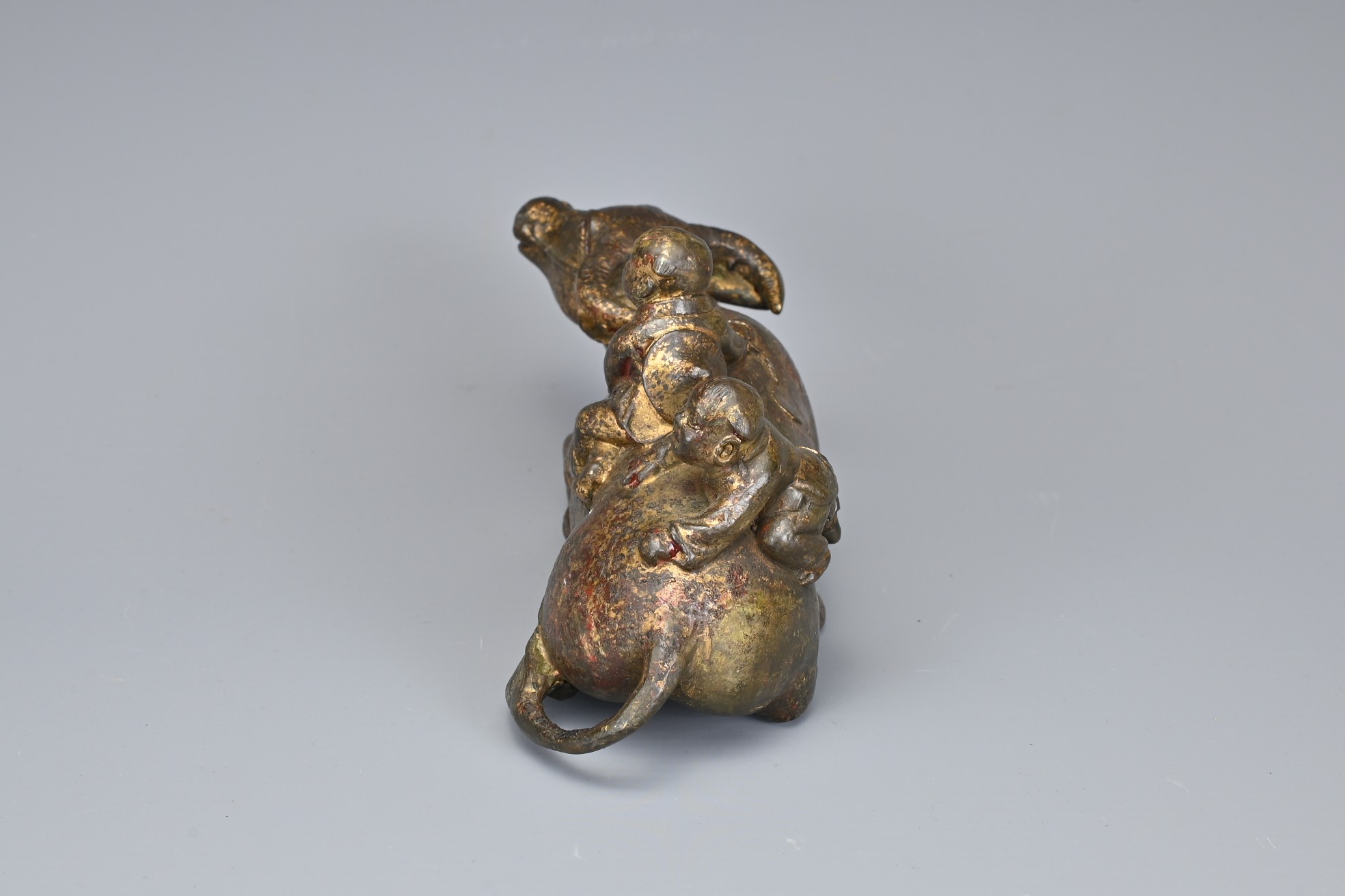 A CHINESE GILT BRONZE MODEL OF A BUFFALO AND BOYS. The recumbent buffalo wearing a rein with on - Image 5 of 7