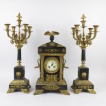 A three-piece Napoleon III clock garniture in black marble and bronze fittings with 2 candlesticks