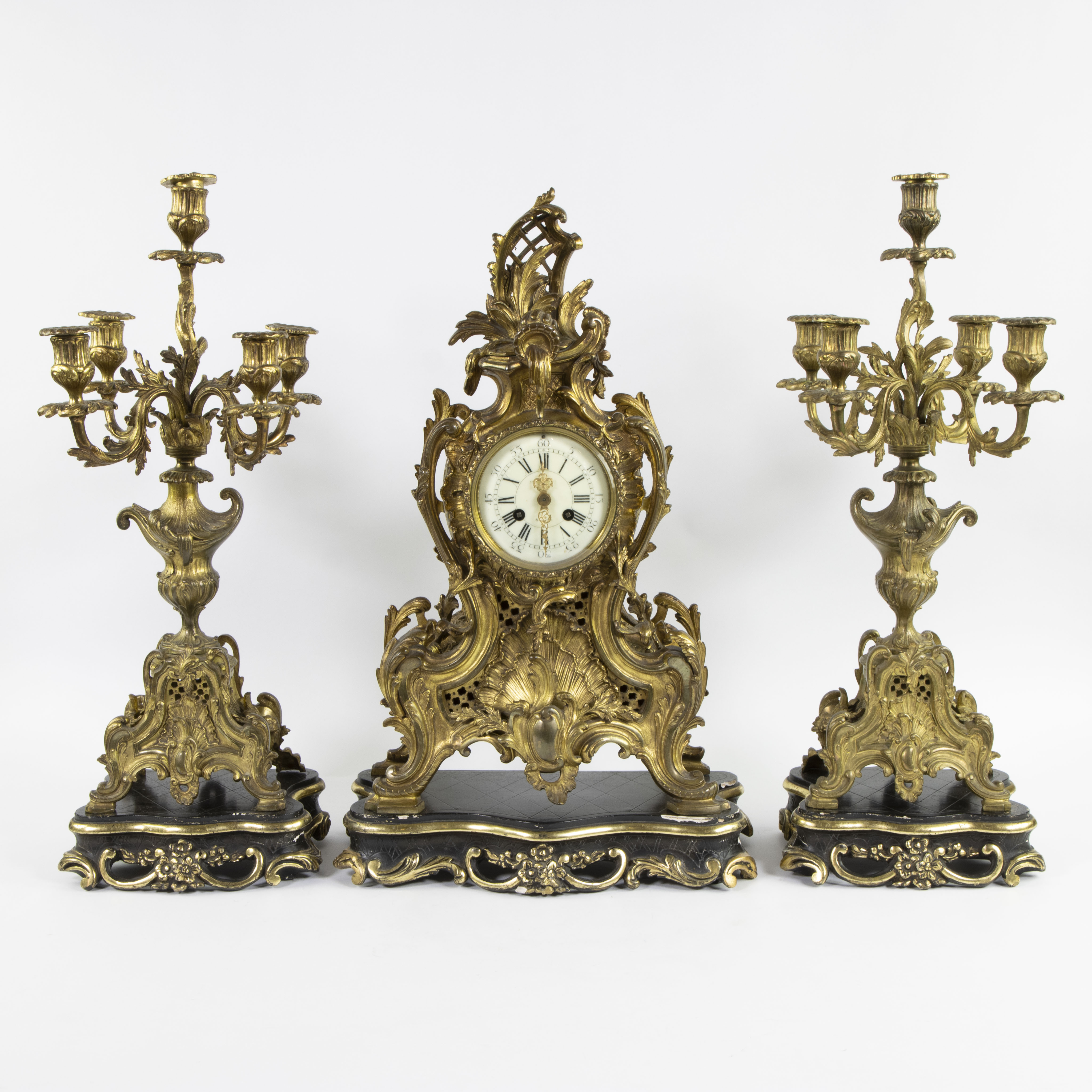 A three-part Louis XV style gilt bronze mantel clock garniture consisting of a clock and candlestick