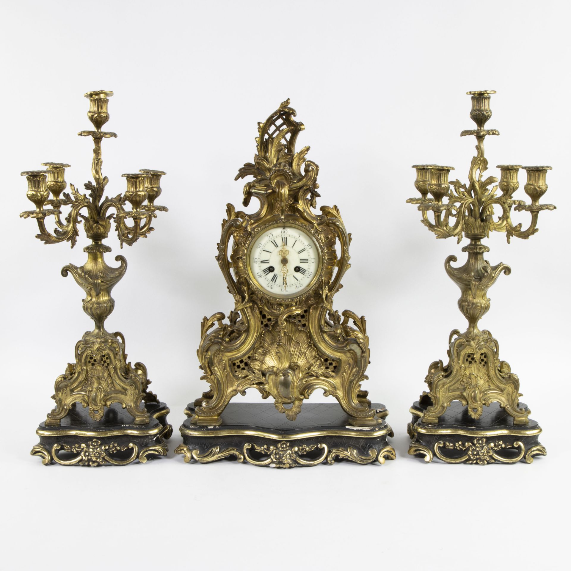 A three-part Louis XV style gilt bronze mantel clock garniture consisting of a clock and candlestick