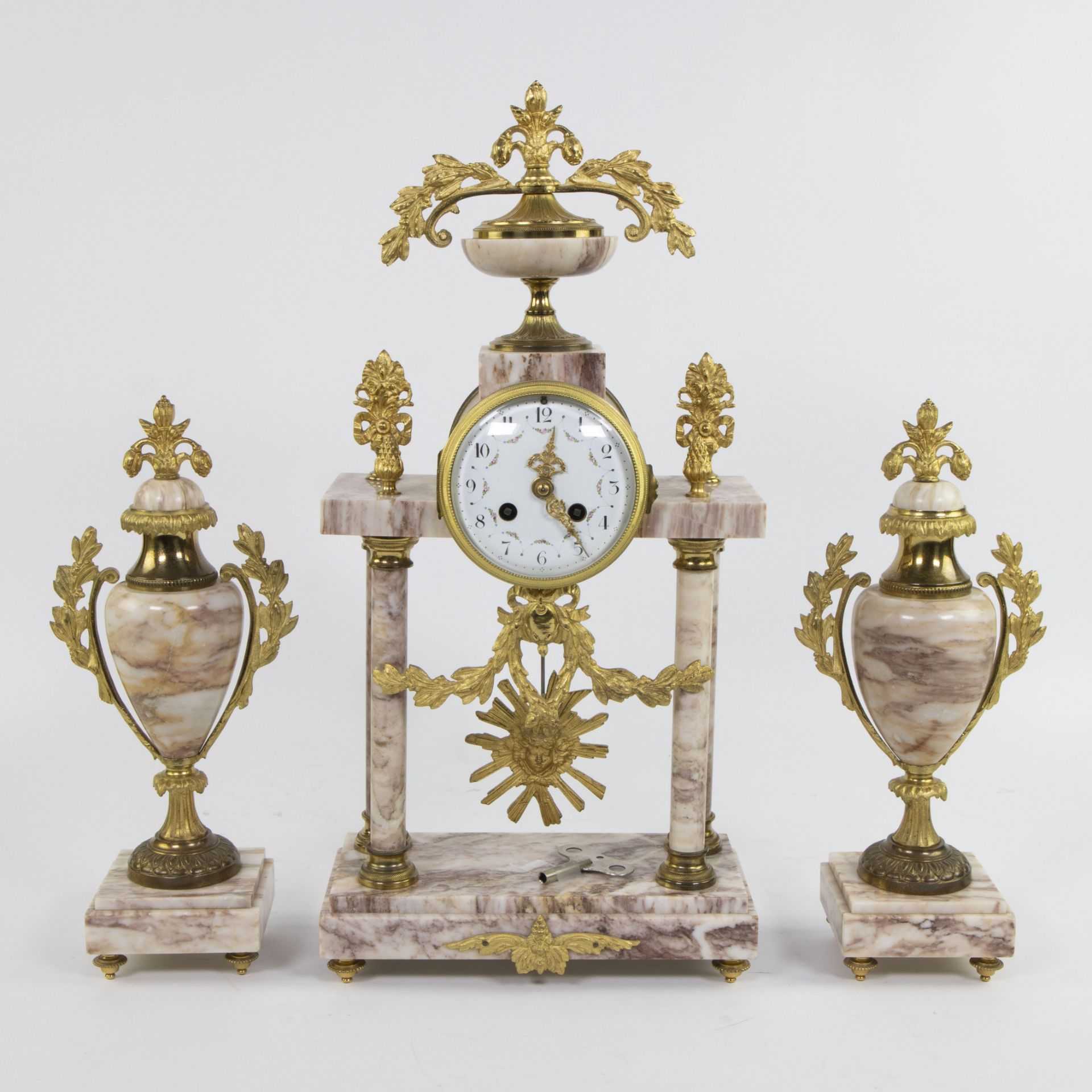 Louis XVI style, mantle garniture comprising a clock in brass with marble columns and two matching c