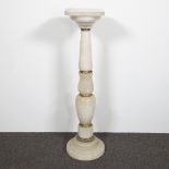 White alabaster column with round decorations in brass