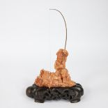 A Chinese Red Coral Sculpture On A Wooden Base depicting a fisherman circa 1900, 643 gram