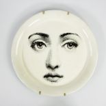 Fornasetti black and white metal wall plate, decorated with the face of the lyrical muse Lina Cava