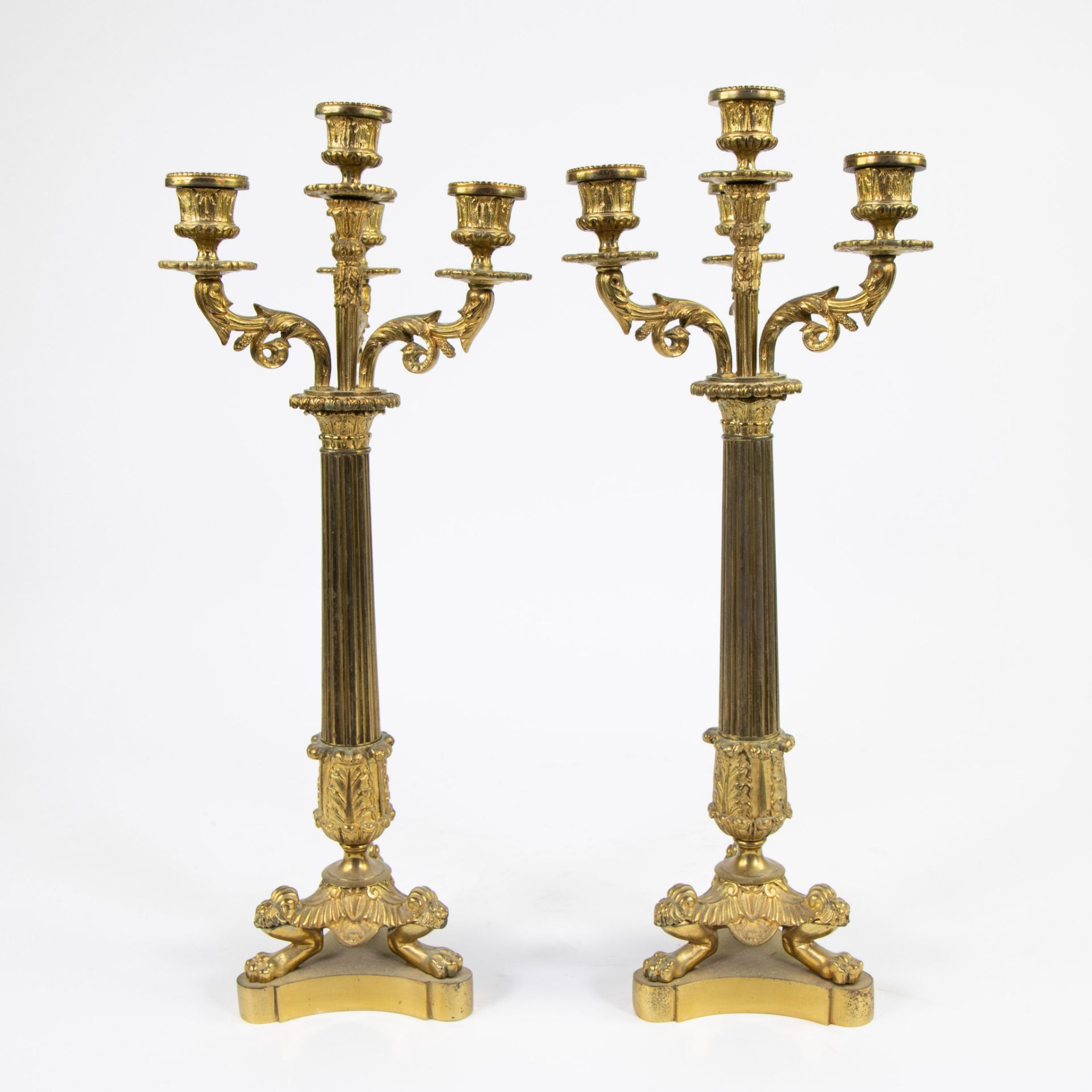 A pair of gilt bronze candlesticks with four light points and on three lion's feet. - Image 2 of 3