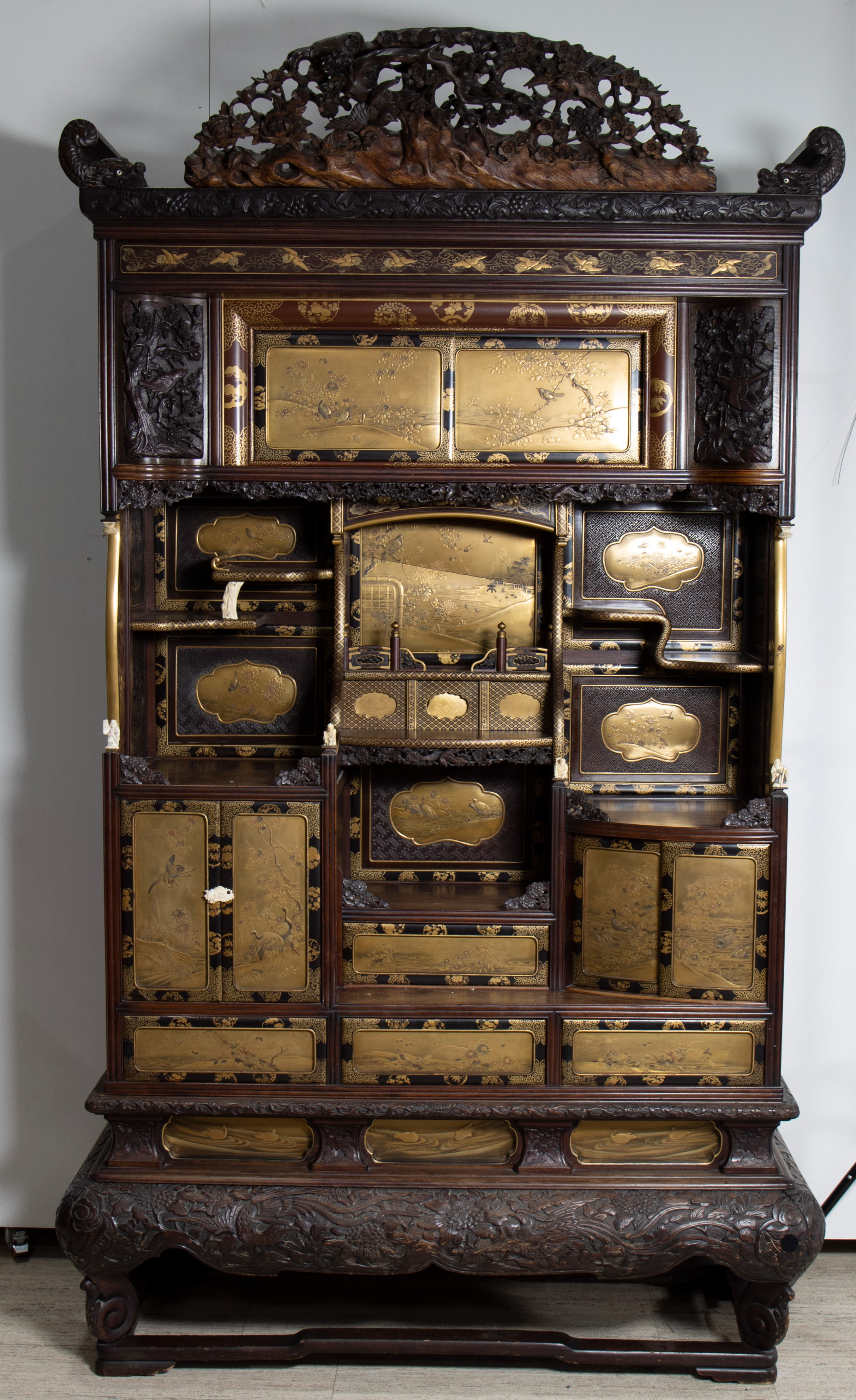 A superb large Shodana cabinet with gold lacquered panels and doors, with open carved crest and frie