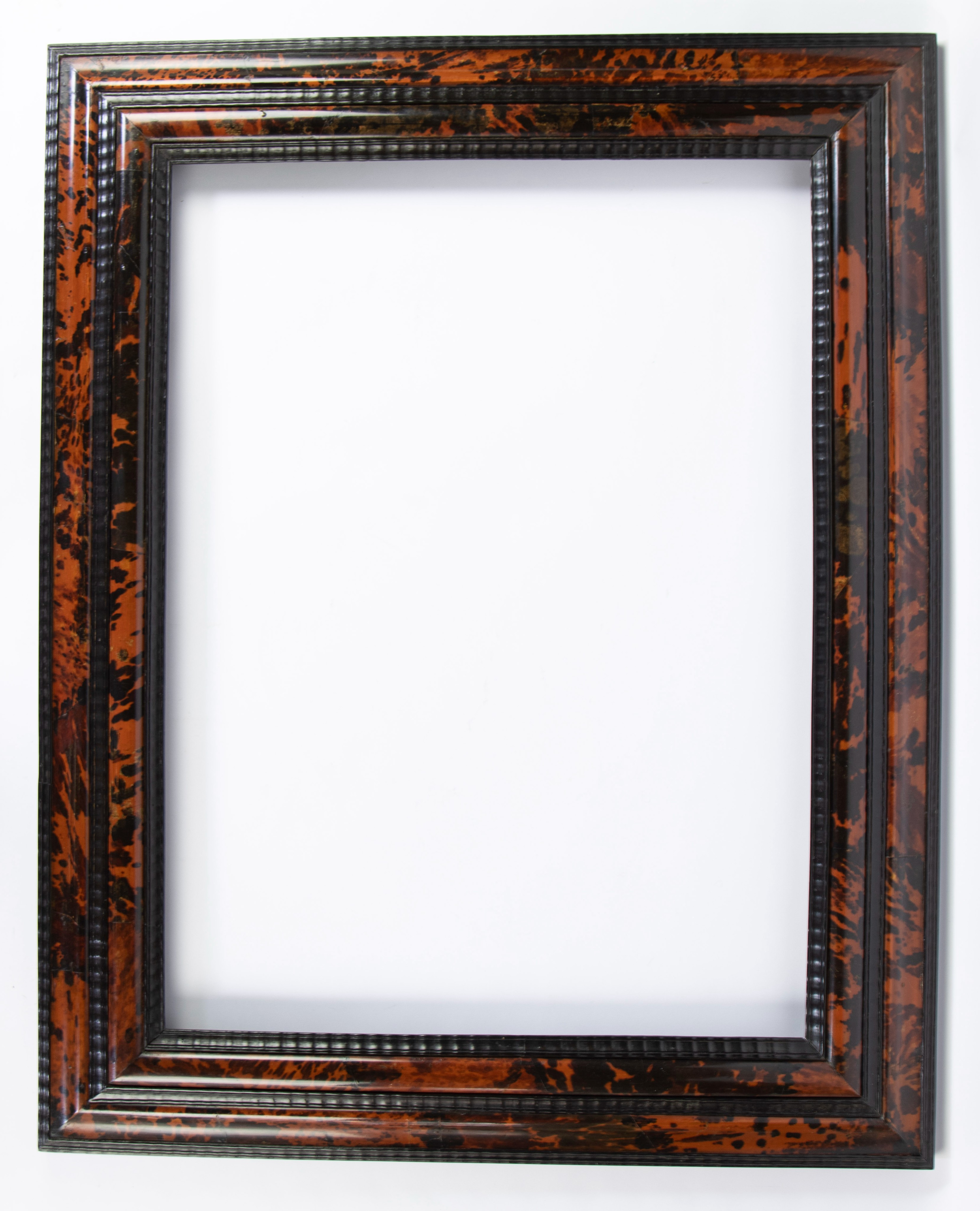 Frame with red tortoiseshell inlaid and ebony rubber moldings.