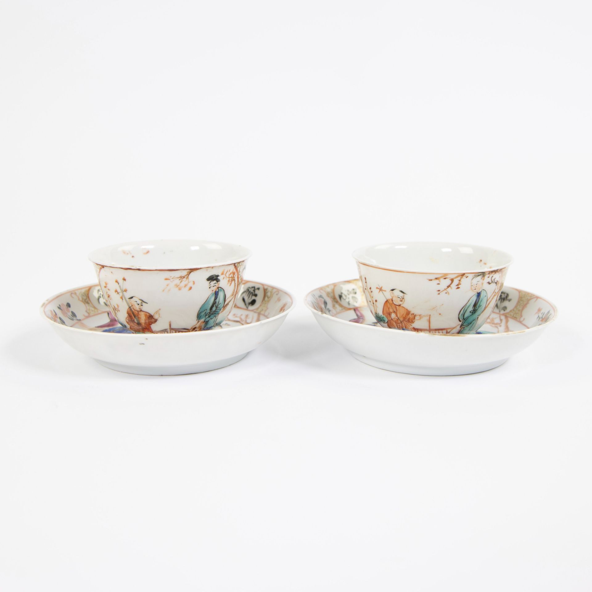 China, a pair of famille rose porcelain plates and cups with Mandarin decor, Qianlong