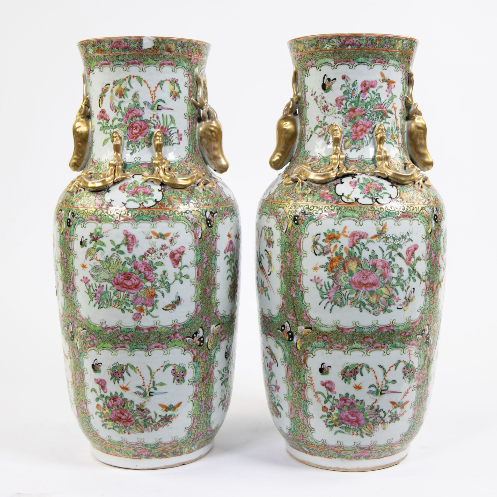 A pair of large Canton porcelain baluster vases, decorated in famille rose enamels with flowers and 