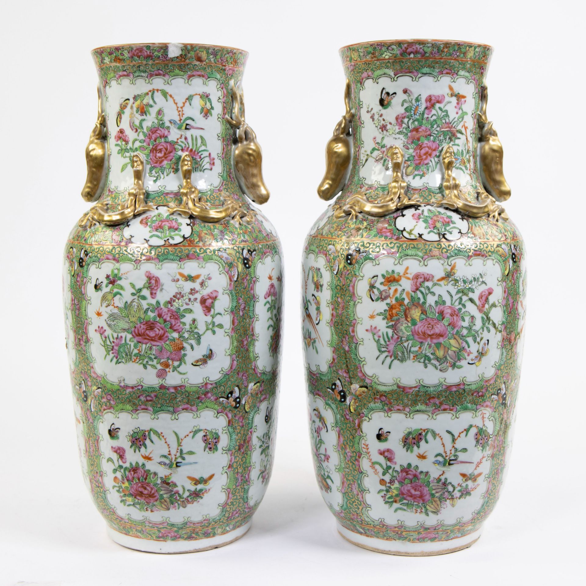 A pair of large Canton porcelain baluster vases, decorated in famille rose enamels with flowers and