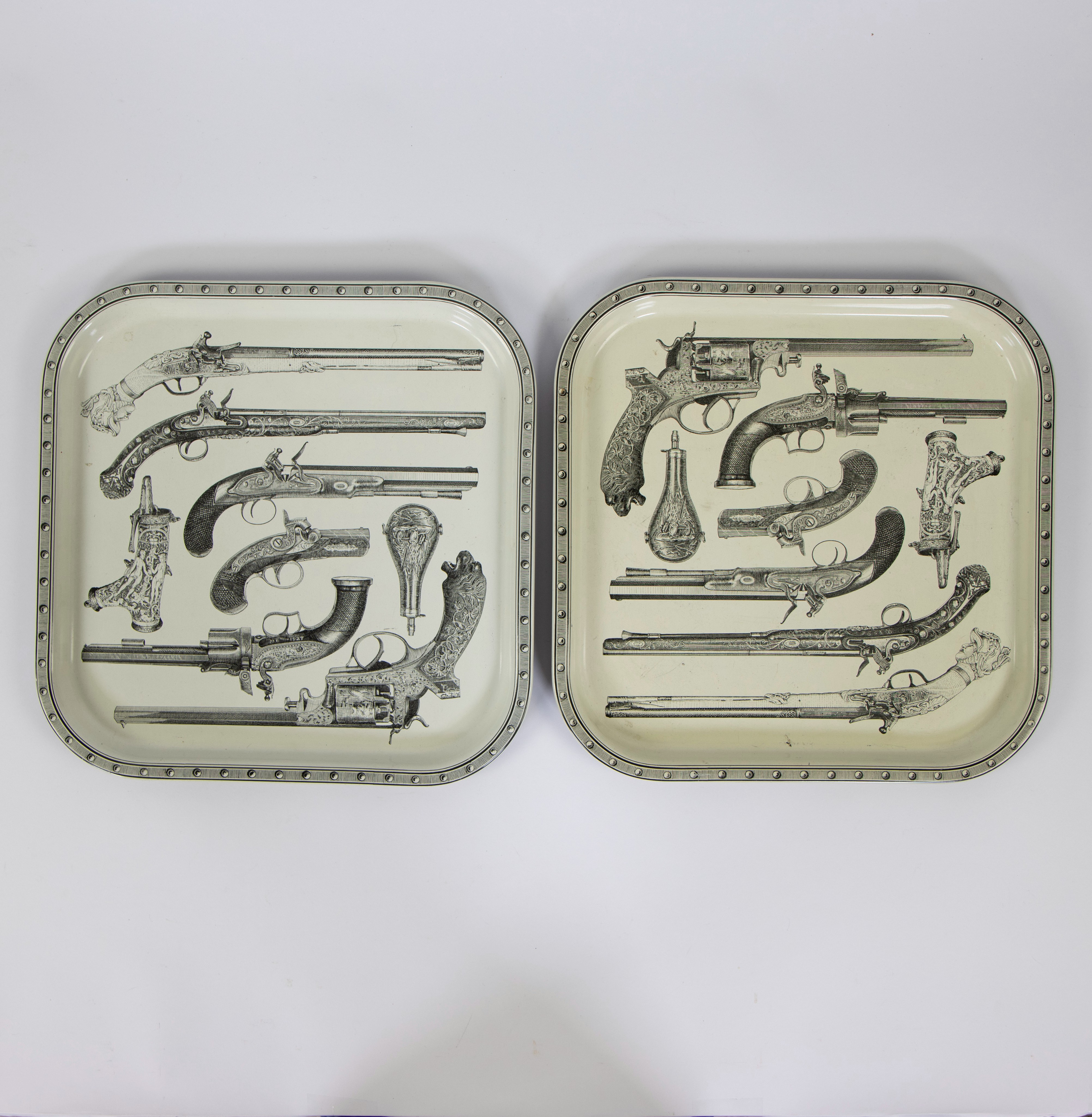 Two beautiful serving trays made of metal, with nice pistol and guns pattern. From the 1960s, unmark