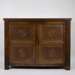 17th century two-door cabinet with rich carving and medallions with heads on the door panels
