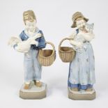 Pair of glazed ceramic statues of boy with goose and girl with cat, Austria ca 1950