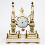 French Directoire mantel clock on white marble base with 2 columns decorated with fire-gilt brass or