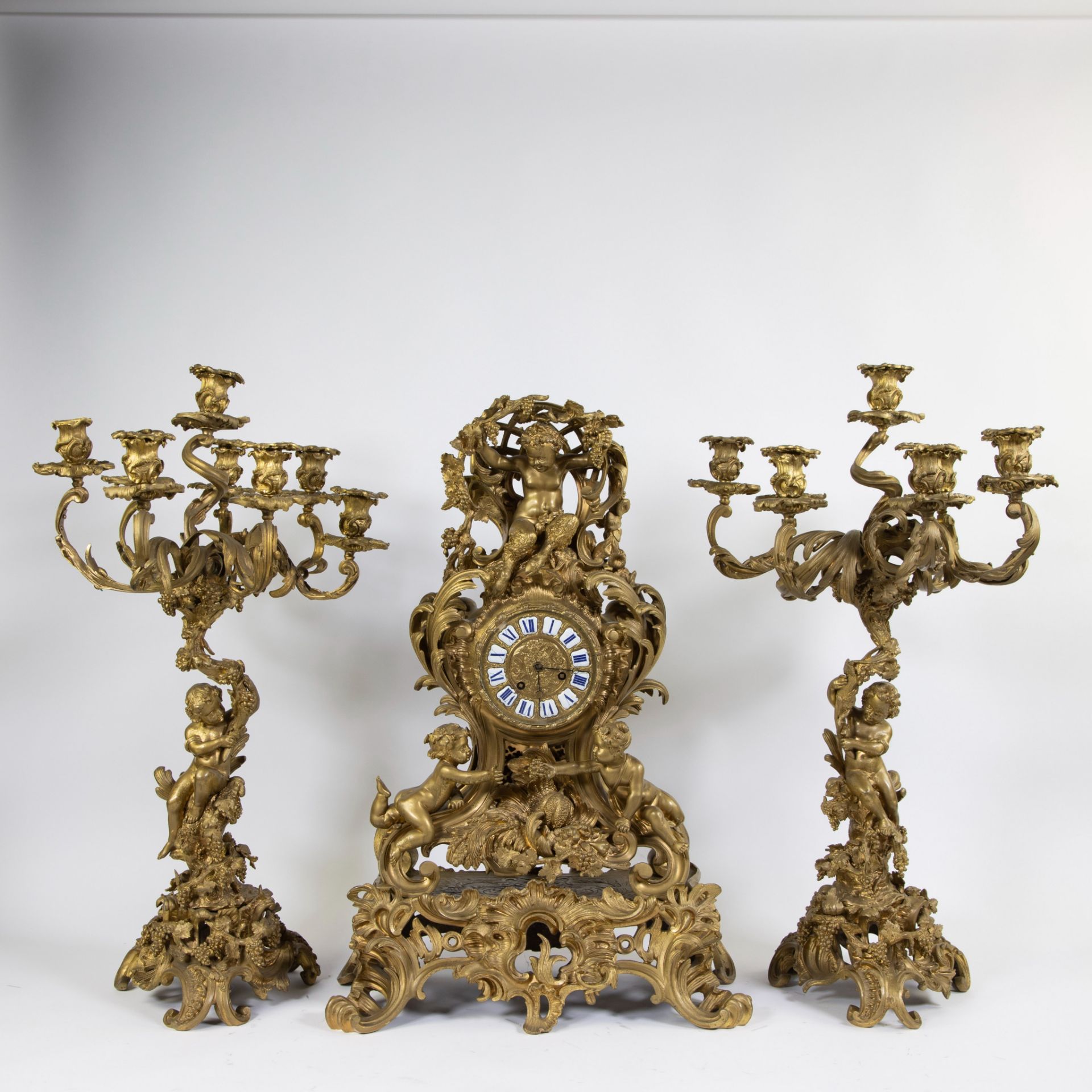 An impressive three-part-piece gilded Louis XV clock from Vincenti à Paris. The mantel clock decorat