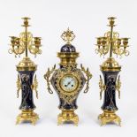 Three piece faience garnish decorated with stylized whiplash motifs and gilt brass, candlesticks wit