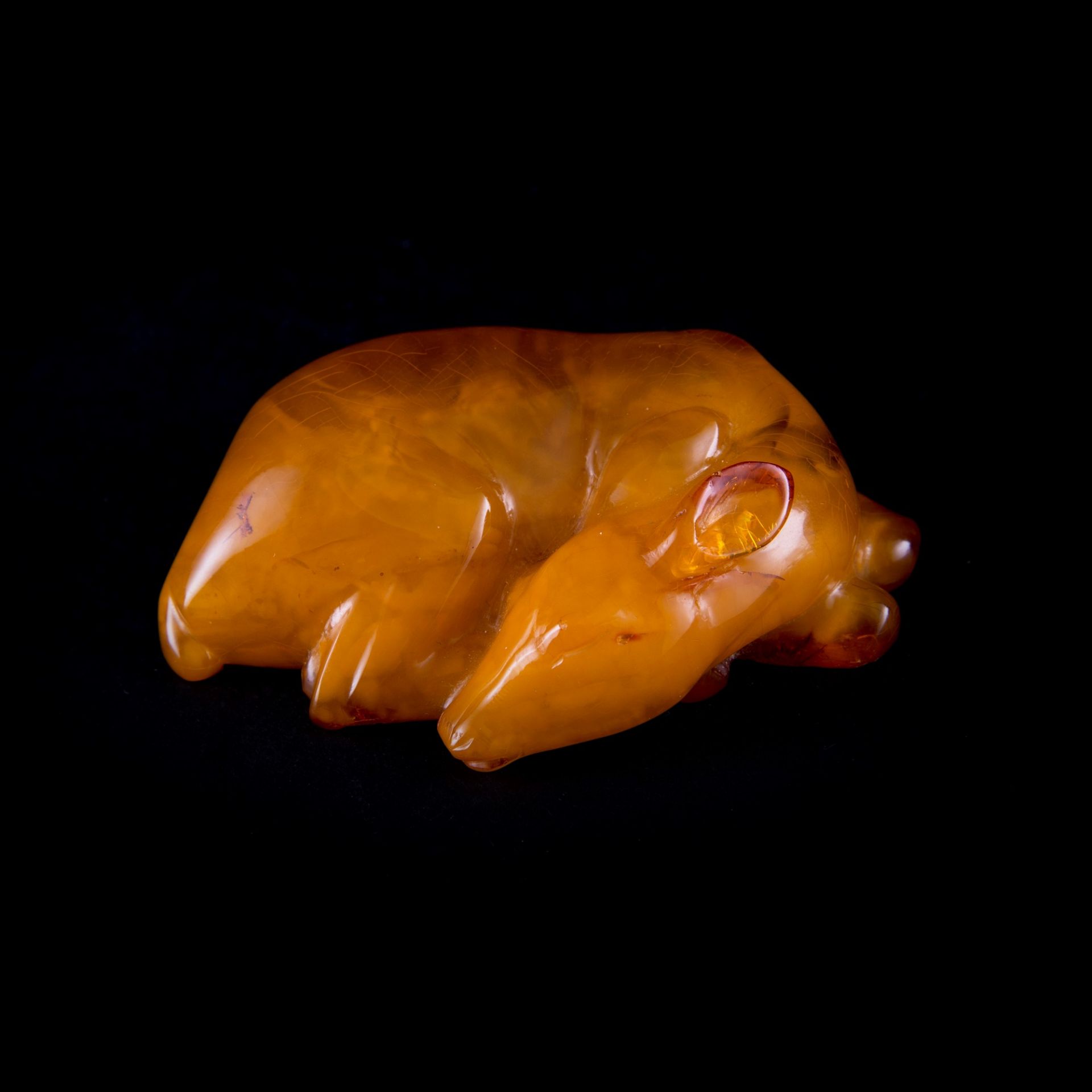 A RARE CARVED AMBER DEER IN RECUMBENT POSE h. 2,5 cm x l. 8 cm