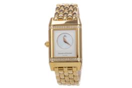 A LADY'S JAEGER LE COULTRE REVERSO EIGHTEEN CARAT GOLD QUARTZ WRIST WATCH