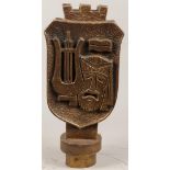 A bronze city coat of arms with harlequin and lute. (plinth